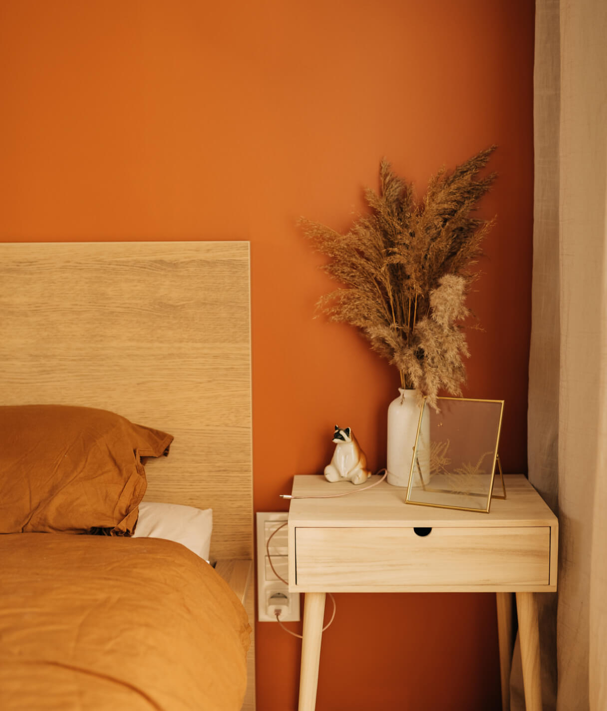 Bed and bedside table in a sunny beach holiday home.